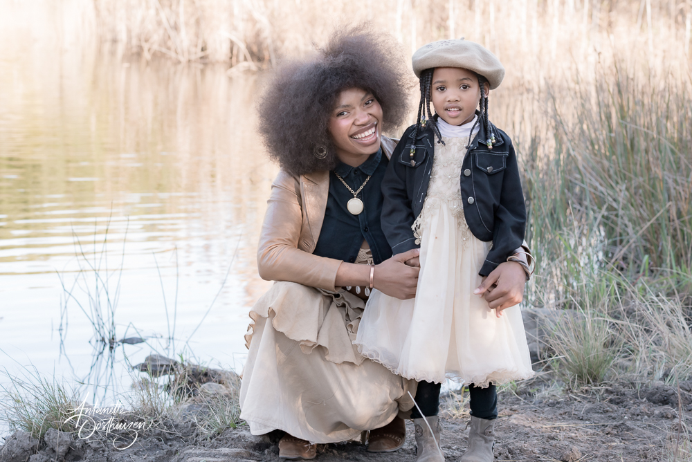 Mom and daughter standing infront of a dam posing